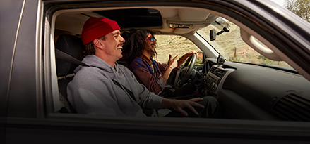 Two men driving in a sport utility vehicle in the mountains