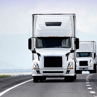 a fleet of trucks moves down the highway fueled by Mobil Delvac products and solutions