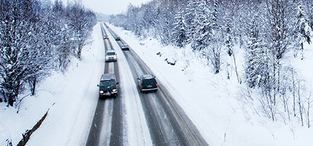 Cars driving on snow covered roads for winter driving safety tips