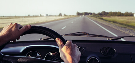 Driver behind the wheel improving gas mileage on the road