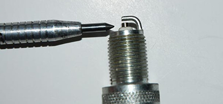 Spark plug ground electrode and center gap with pointer Spark plug ground electrode and center gap with pointer