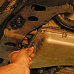 Mechanic attaches new gasket to pan with oil-soluble grease