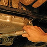 Mechanic attaches new gasket to pan with oil-soluble grease