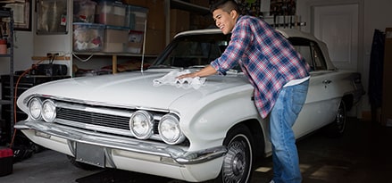 man cleaning his white car