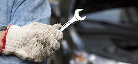 Close up of a man’s gloved hand holding a wrench