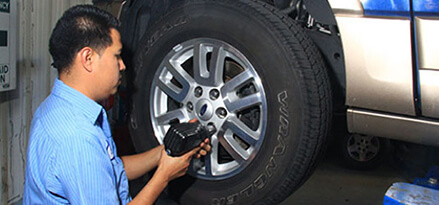 Mechanic rotates and inflates tire to make car last longer