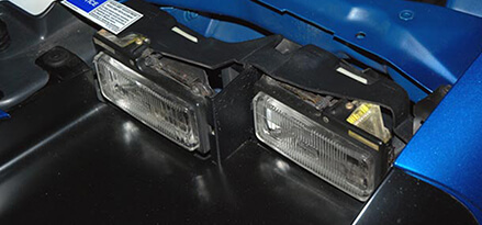 Checking the front bulbs of blue car headlights