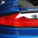 Checking taillight bulbs on the backside of blue car