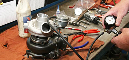 Turbocharger wastegate actuator being pressure tested