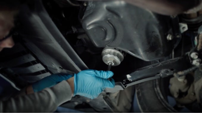 An Image of someone removing an oil filter from a vehicle.