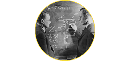 Researchers writing on chalkboard