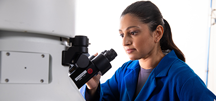 Mobil technician looking at a sample in a microscope