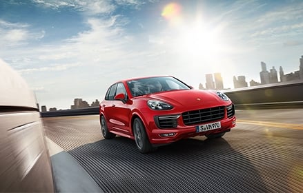 Red Porsche in front of a sunny skyline Red Porsche in front of a sunny skyline