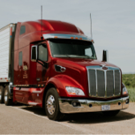 Front side view of truck with red cab on highway