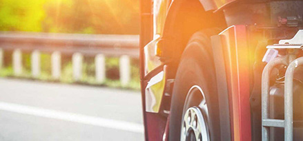 Sun flare shining on lower part of truck cab driving on highway 