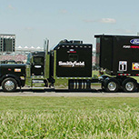 Sideview of large black truck featuring Smithfield company name parked outside event