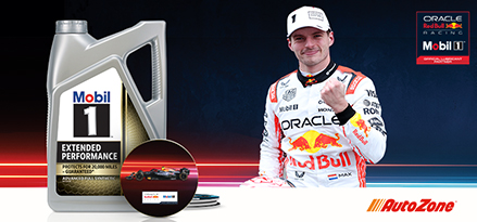Racer, Max Verstappen, next to large motor oil bottle and coaster in front of graphic image.