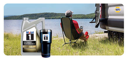 A man relaxes in a camping chair beside a lake