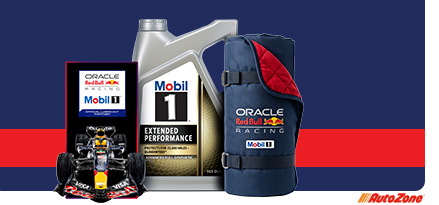 A red and blue background with an Oracle Red Bull Racing and Mobil 1 LED sign on the left, a Mobil 1 extended performance bottle in the middle, and a neatly rolled and buckled outdoor blanket to the right.