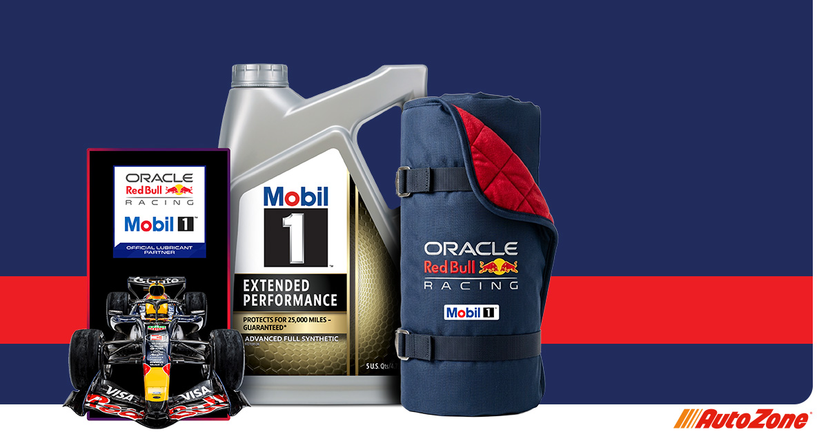 A red and blue background with an Oracle Red Bull Racing and Mobil 1 LED sign on the left, a Mobil 1 extended performance bottle in the middle, and a neatly rolled and buckled outdoor blanket to the right.