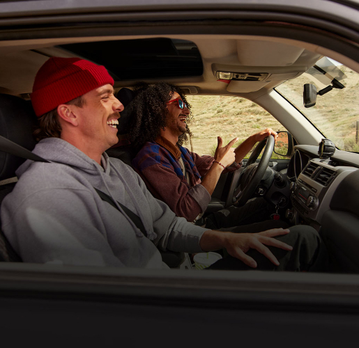 Two men driving in a sport utility vehicle in the mountains