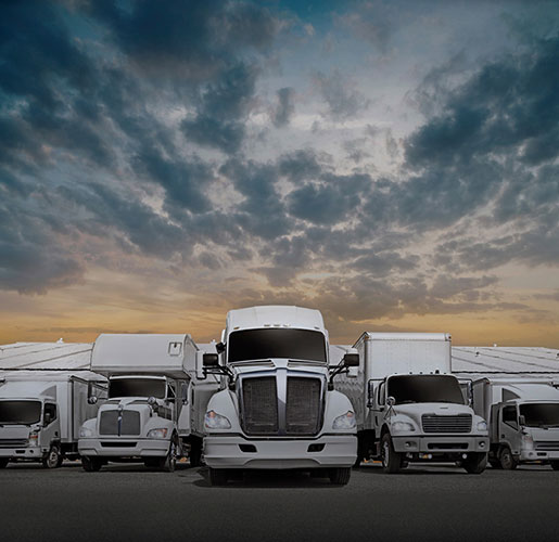 Truck fleet of cargo trucks and a trailer outside a distribution center